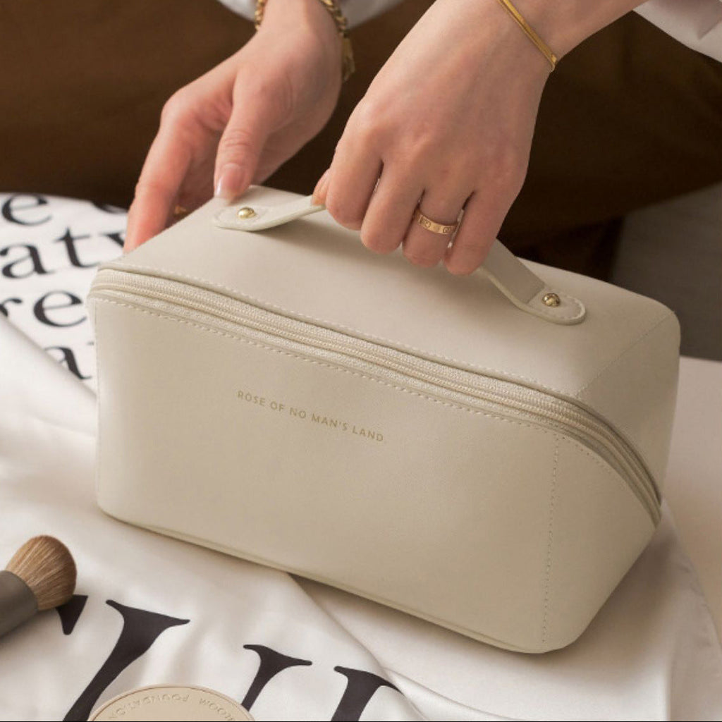 Beige cosmetic bag with 'Rose of No Man's Land' branding on a white surface with text.